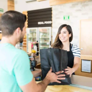 Cajera de supermercado atendiendo a un cliente, representante del sector comercio en Tenerife